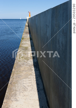 Concrete cape in the sea with white sail 29503290