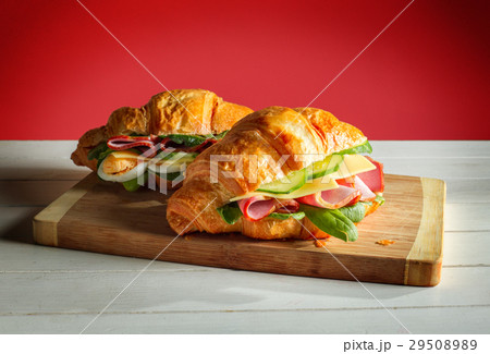 Croissants sandwiches on the wooden cutting board 29508989