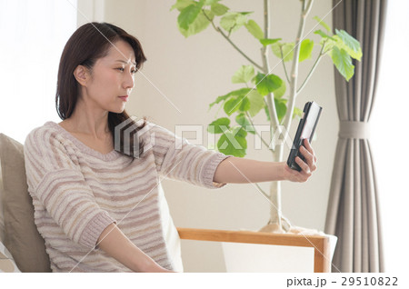 スマホ老眼のミドル女性 29510822