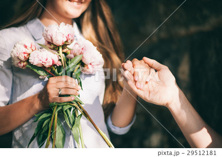 woman with engagement ring and peony bouquet 29512181