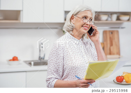 Mature woman calling utility service at home 29515998