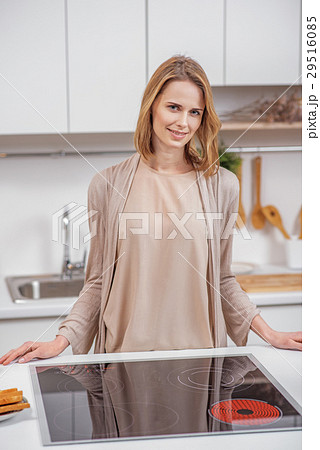 Cheerful housewife preparing dinner at home Cheerful housewife preparing dinner at home 29516085