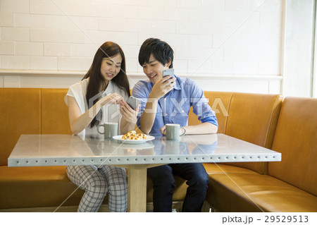 カフェでコーヒーを飲む20代男女 29529513