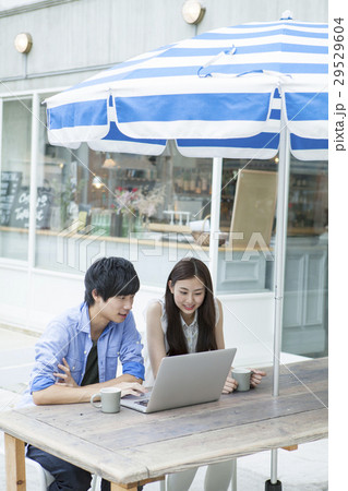 テラスでPCを使う20代男女 29529604
