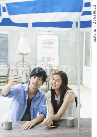 カフェでスマホを使う20代男女 29529622