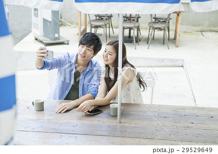 カフェでスマホを使う20代男女 29529649