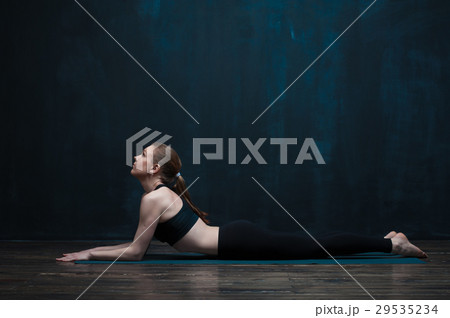 Side view of flexible woman doing yoga indoors 29535234