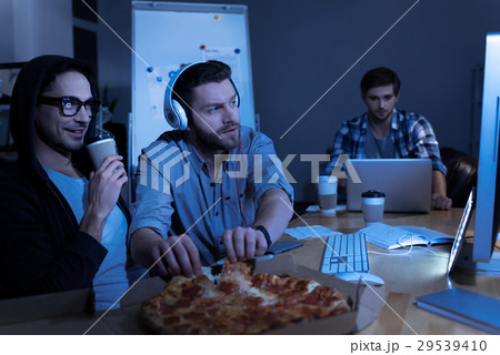 Pleasant positive programmer taking pizza slices 29539410