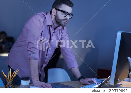 Serious concentrated man standing at the table Serious concentrated man standing at the table 29539892