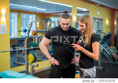 Fit attractive young couple at a gym looking at a 29541878