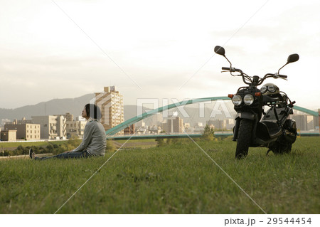 バイクと河川敷の女性 29544454