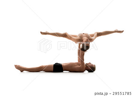 Male acrobat exercises with young girl in studio Male acrobat exercises with young girl in studio 29551785