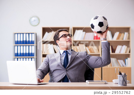 Businessman with football ball in office Businessman with football ball in office 29552762