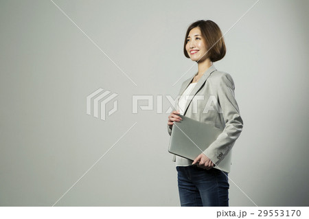 ノートパソコンを持つ笑顔の20代女性 29553170