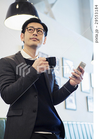 カフェでスマホを見る30代男性 カフェでスマホを見る30代男性 29553184