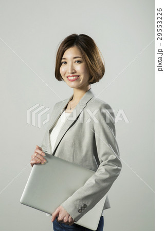 ノートパソコンを持つ笑顔の20代女性 29553226