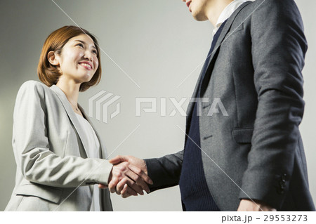 笑顔で握手をする男女 笑顔で握手をする男女 29553273