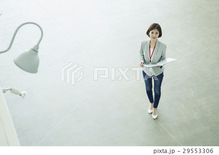 ファイルを持つ仕事中の20代女性 ファイルを持つ仕事中の20代女性 29553306