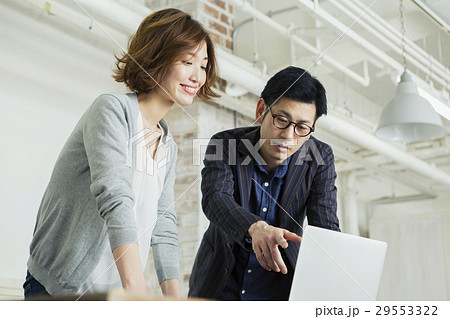 パソコンを見る笑顔の男女 29553322