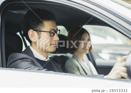 車を運転する男性と助手席に座る女性 29553332