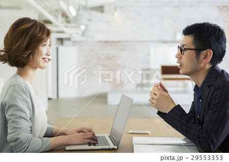 男性と会話をする仕事中の20代女性 29553353