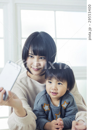リビングで自撮り写真を撮る親子 リビングで自撮り写真を撮る親子 29553400