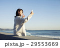 波打ち際で自撮り写真を撮る20代女性 29553669