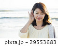 波打ち際で耳をすませる20代女性 29553683