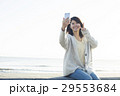 波打ち際で自撮り写真を撮る20代女性 29553684