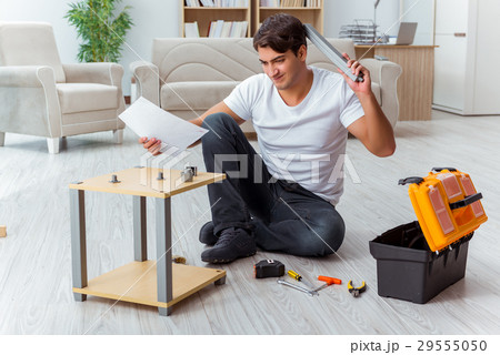 Man assembling furniture at home Man assembling furniture at home 29555050