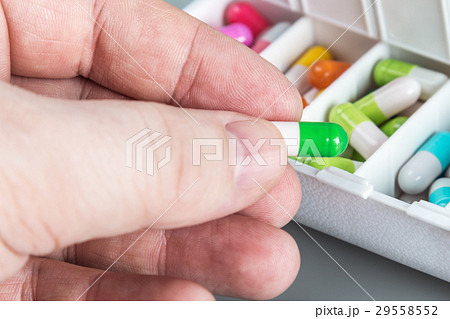 Pill in hand on the background of the box   29558552