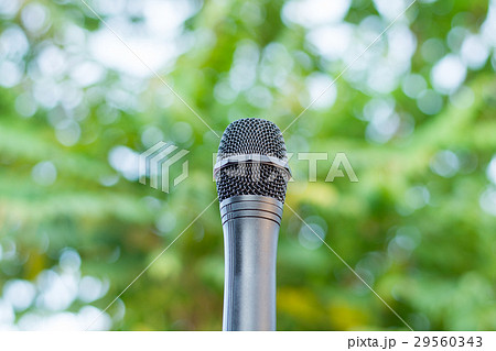 Black microphone in a park with defocused bokeh  29560343