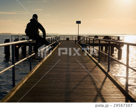 Tourist sit on mole handrail and takes pictures. Tourist sit on mole handrail and takes pictures. 29567307