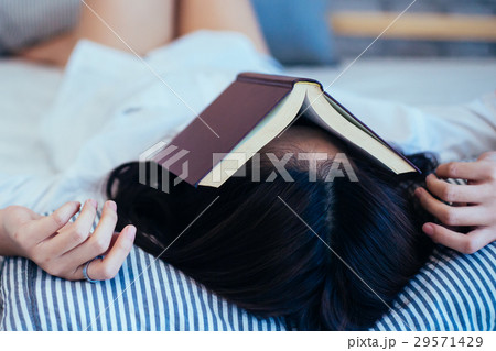 Female teen falls asleep while reading the book Female teen falls asleep while reading the book 29571429