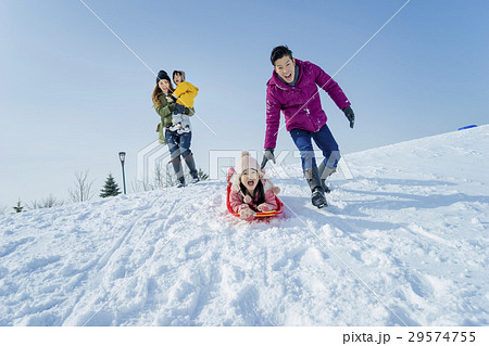雪遊びをする4人家族の写真素材