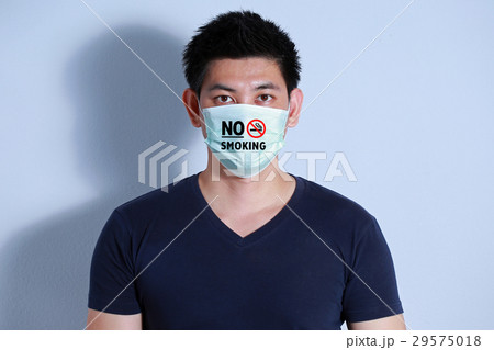 young man smoking cigarette with protective mask young man smoking cigarette with protective mask 29575018