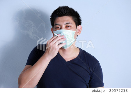 young man smoking cigarette with  protective mask 29575258