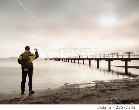 Hiker with backpack alone on beach, sea bridge. Hiker with backpack alone on beach, sea bridge. 29577543