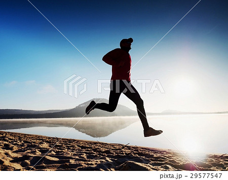Man running on lake beach at sunrise.Healthy style 29577547