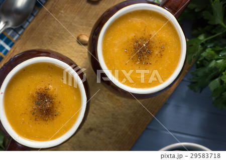 pumpkin cream soup in mugs on  gray blue  29583718