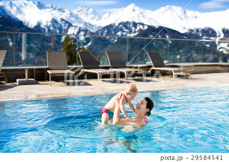 Family in outdoor swimm pool of alpine spa resort Family in outdoor swimm pool of alpine spa resort 29584541