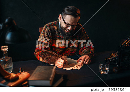 Bearded writer in glasses writes with a feather Bearded writer in glasses writes with a feather 29585364