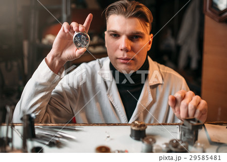 Watch maker holding wrist watch in hand 29585481