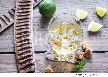 Glass of rum on the wooden background Glass of rum on the wooden background 29585663