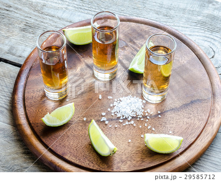 Glasses of tequila on the wooden board Glasses of tequila on the wooden board 29585712