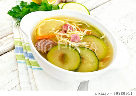 Soup with zucchini and noodles on light board 29589911