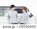 車の前で会話してる20代カップル 29590945