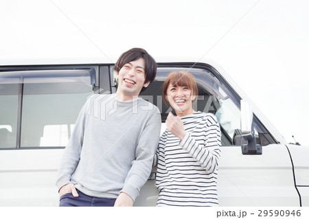 車の前で会話してる20代カップル 29590946
