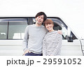 車の前で会話してる20代カップル 29591052
