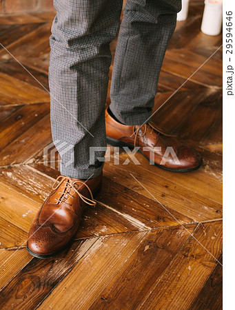 the man's legs in checkered trousers and brown 29594646